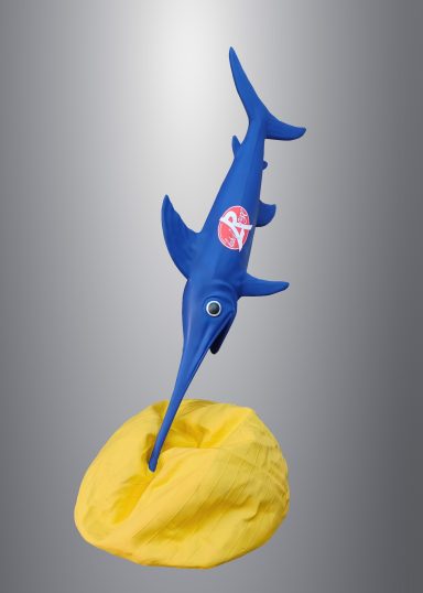 Poisson en plastique bleu sur une base jaune, avec un logo rouge sur le flanc.