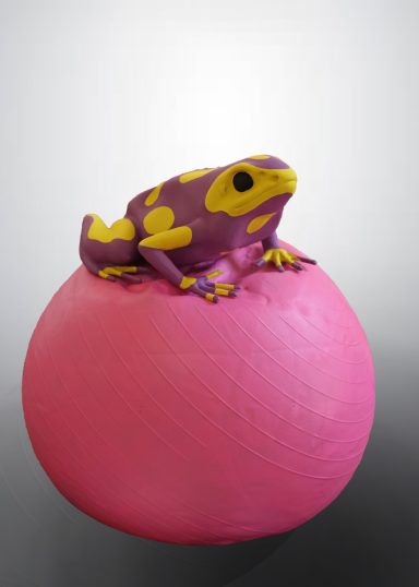 Grenouille jaune et violet posée sur une boule rose.